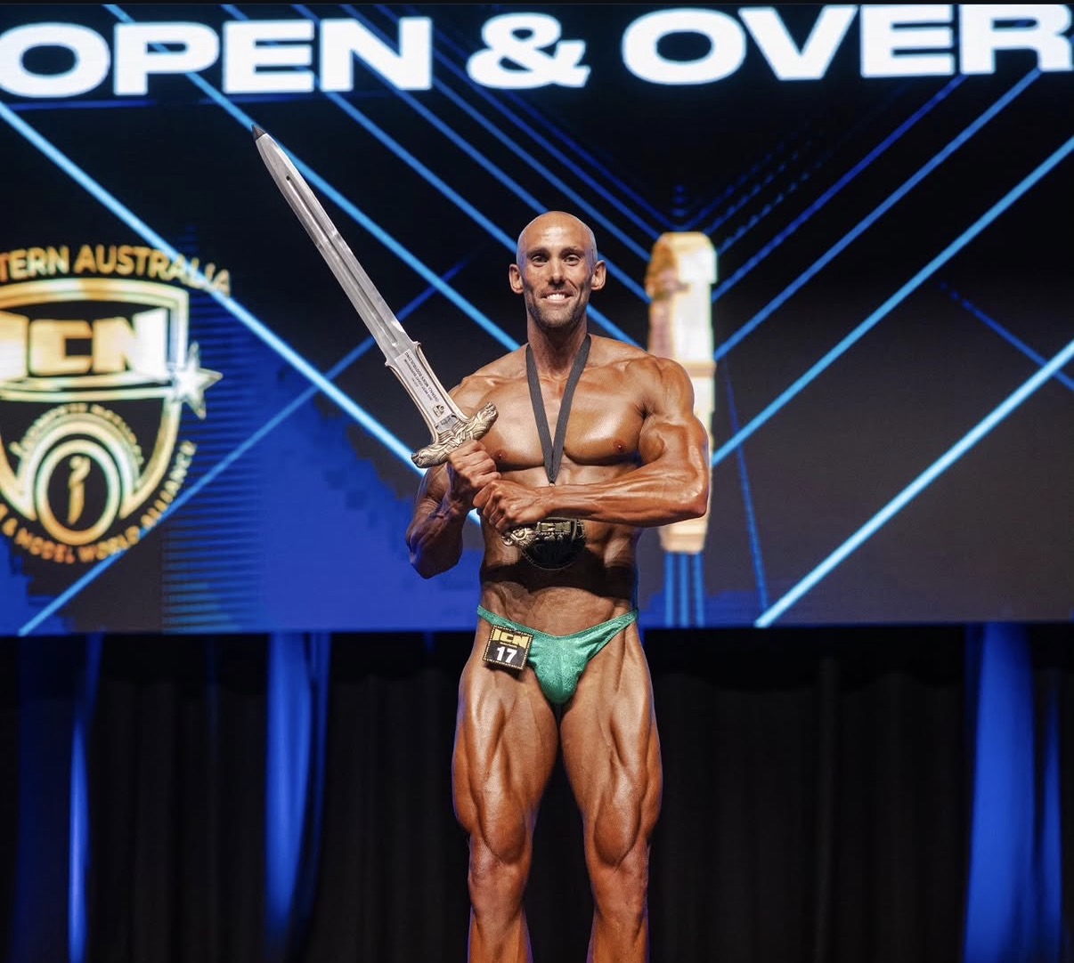 George on stage after winning the natural bodybuilding overall title